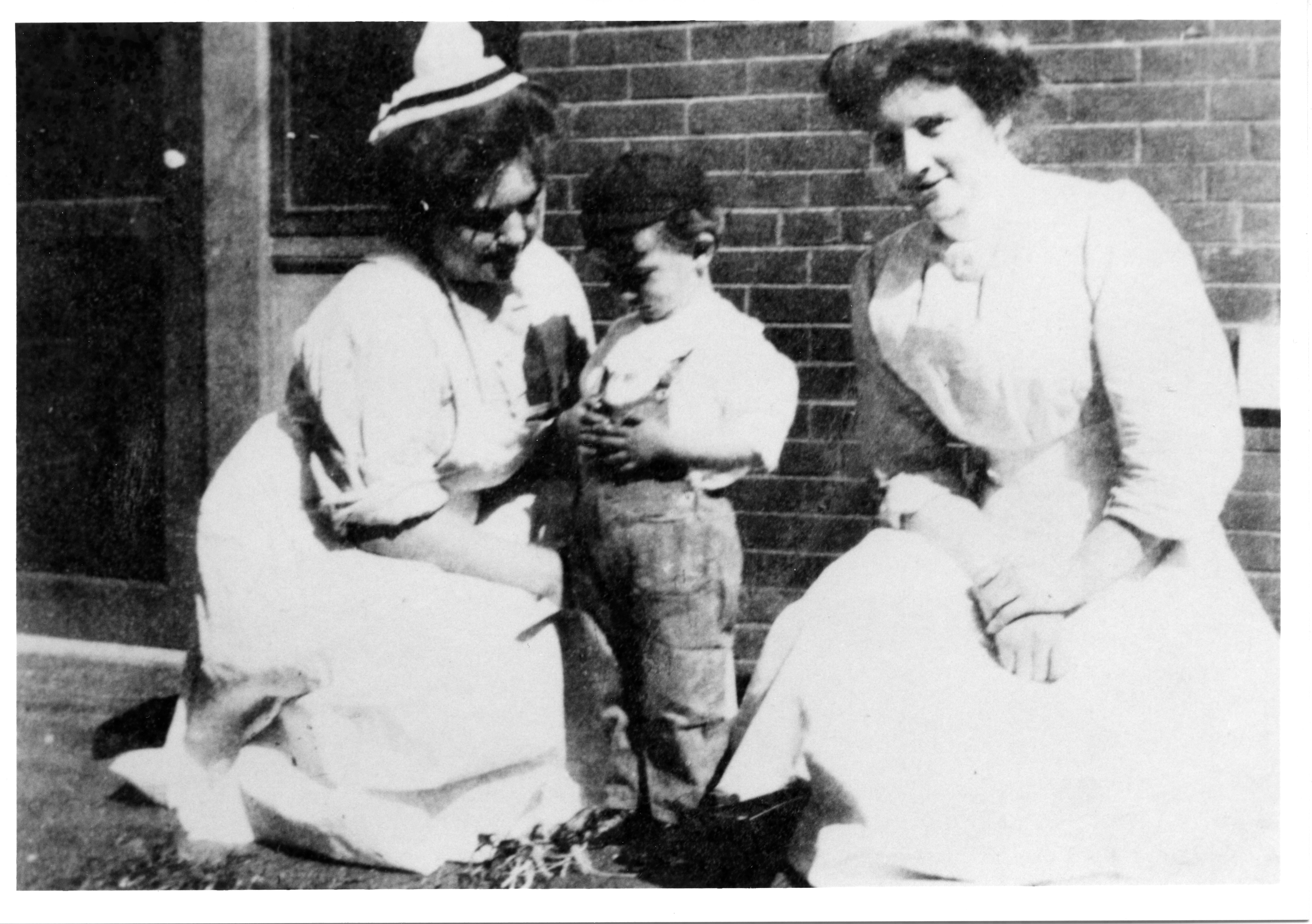 Child with Two Nurses Outside Hospital