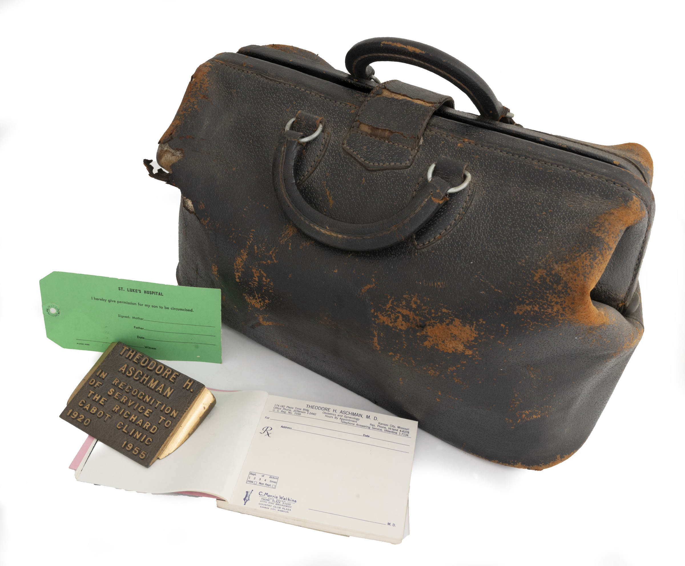 Worn brown leather doctor's bag with plaque, tag, and prescription book