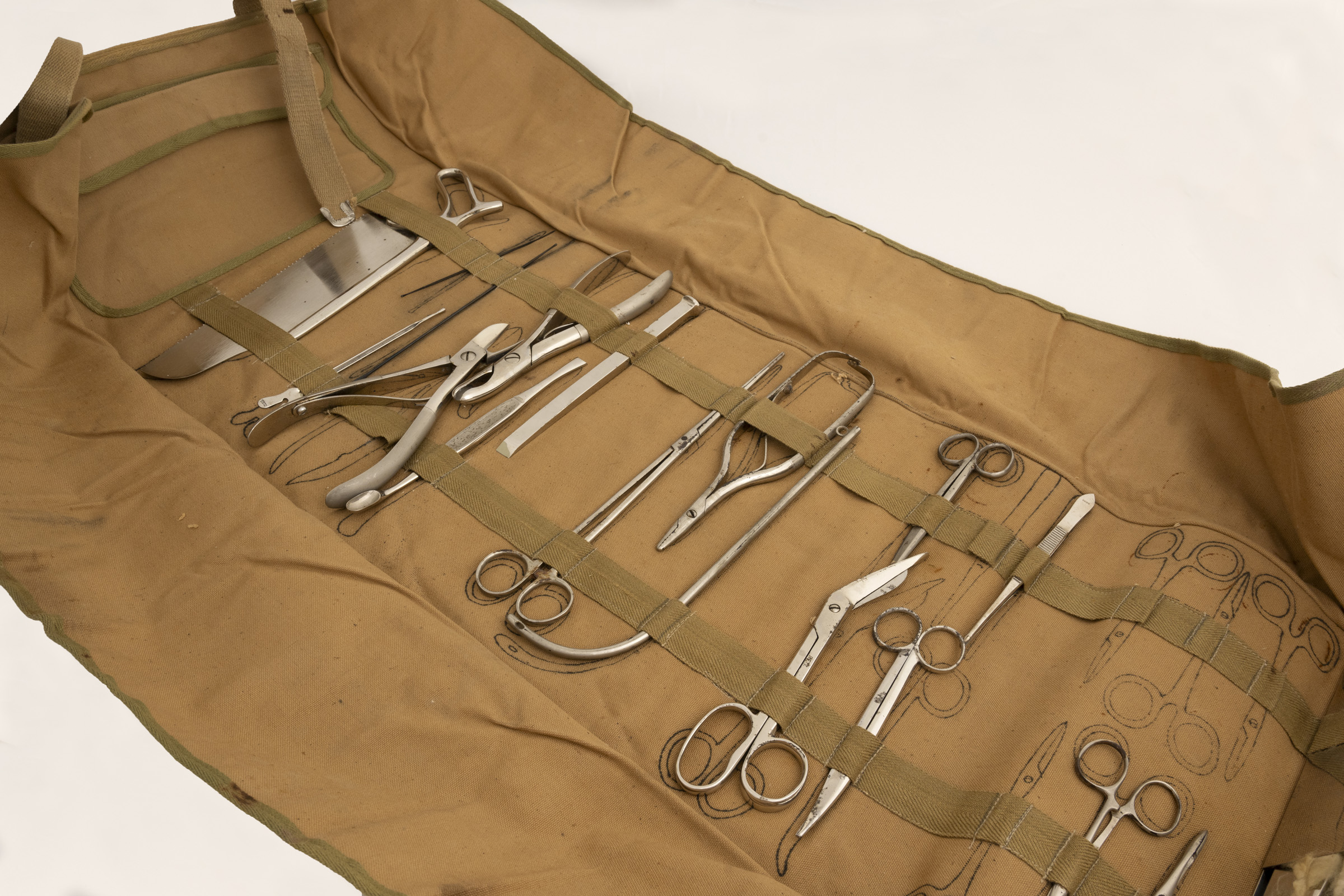 Beige canvas roll, spread out, with surgical instruments.