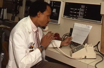 Doctor in a white coat talking on the phone holding a patient&#039;s chart